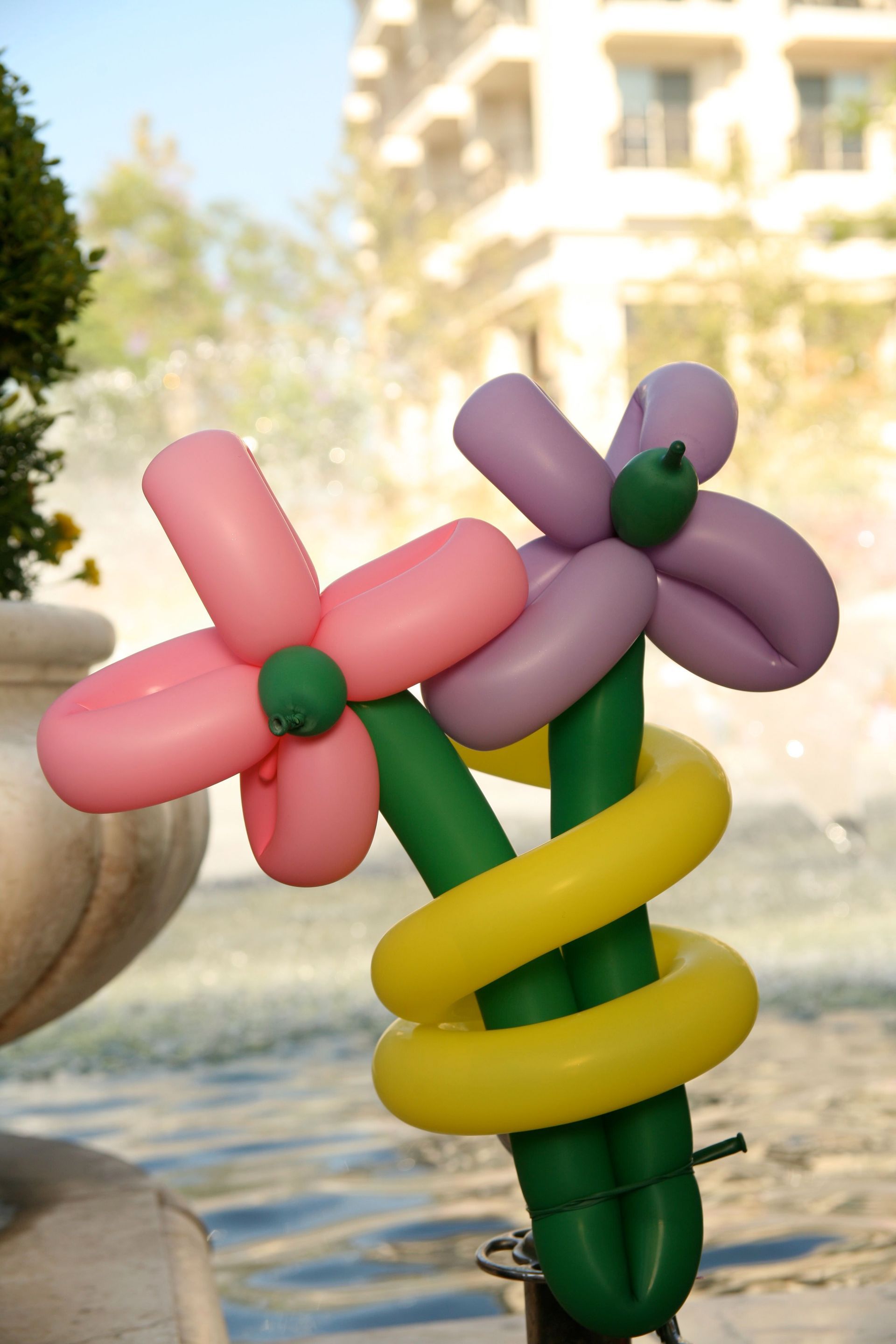 A pink and purple flower made out of balloons