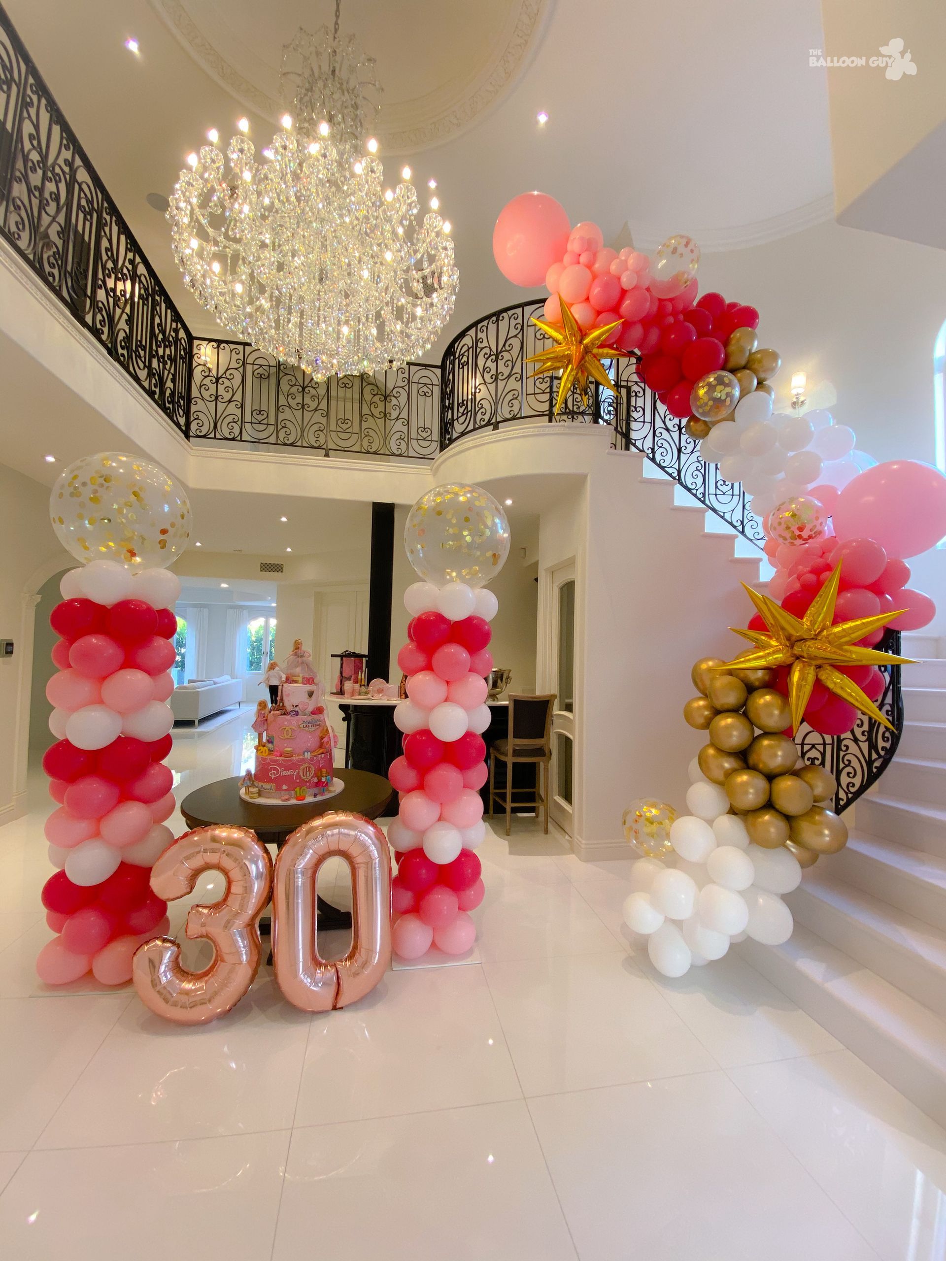 A room decorated with balloons and a cake for a 30th birthday