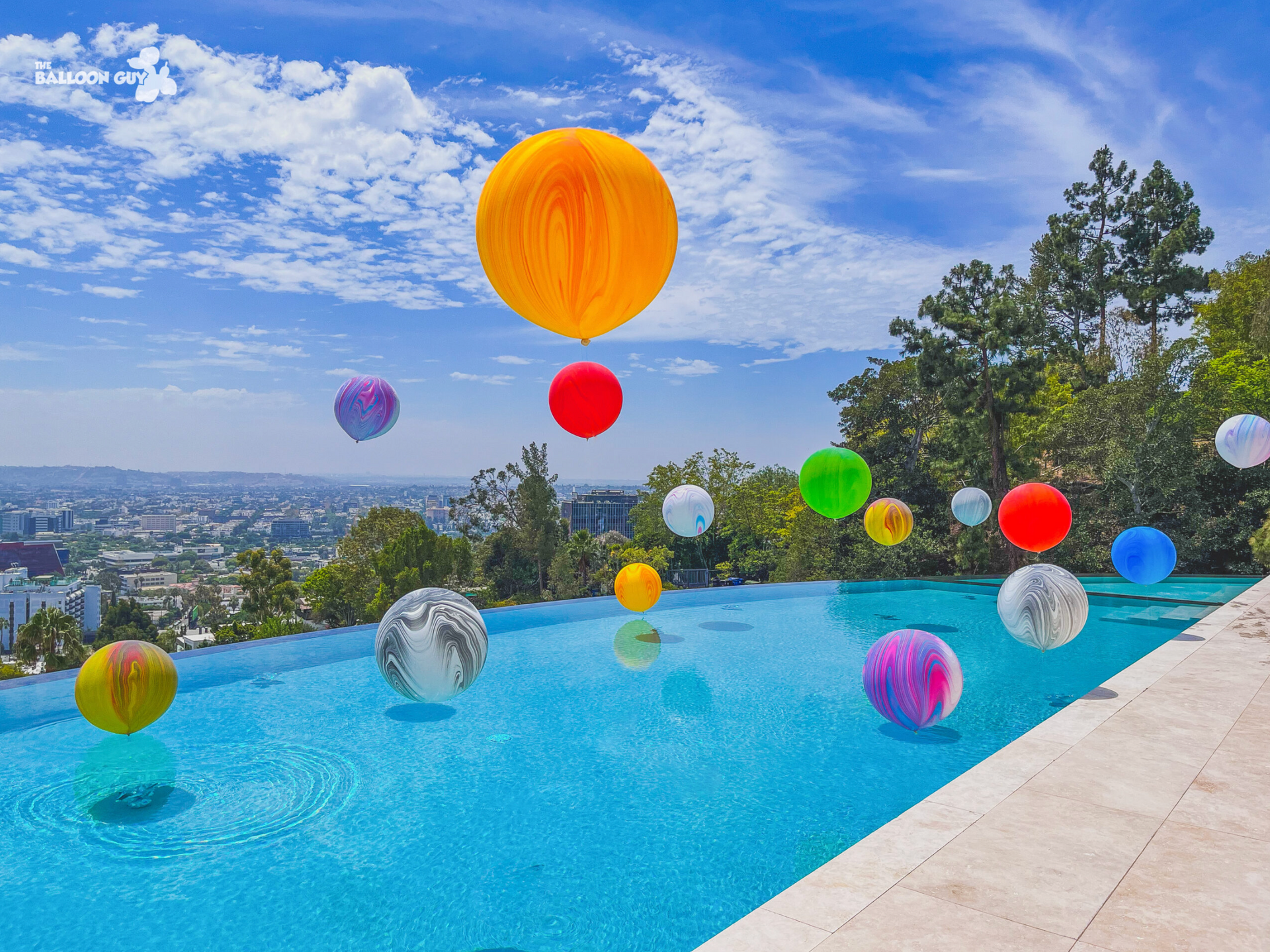 A bunch of colorful balloons are floating in a swimming pool.