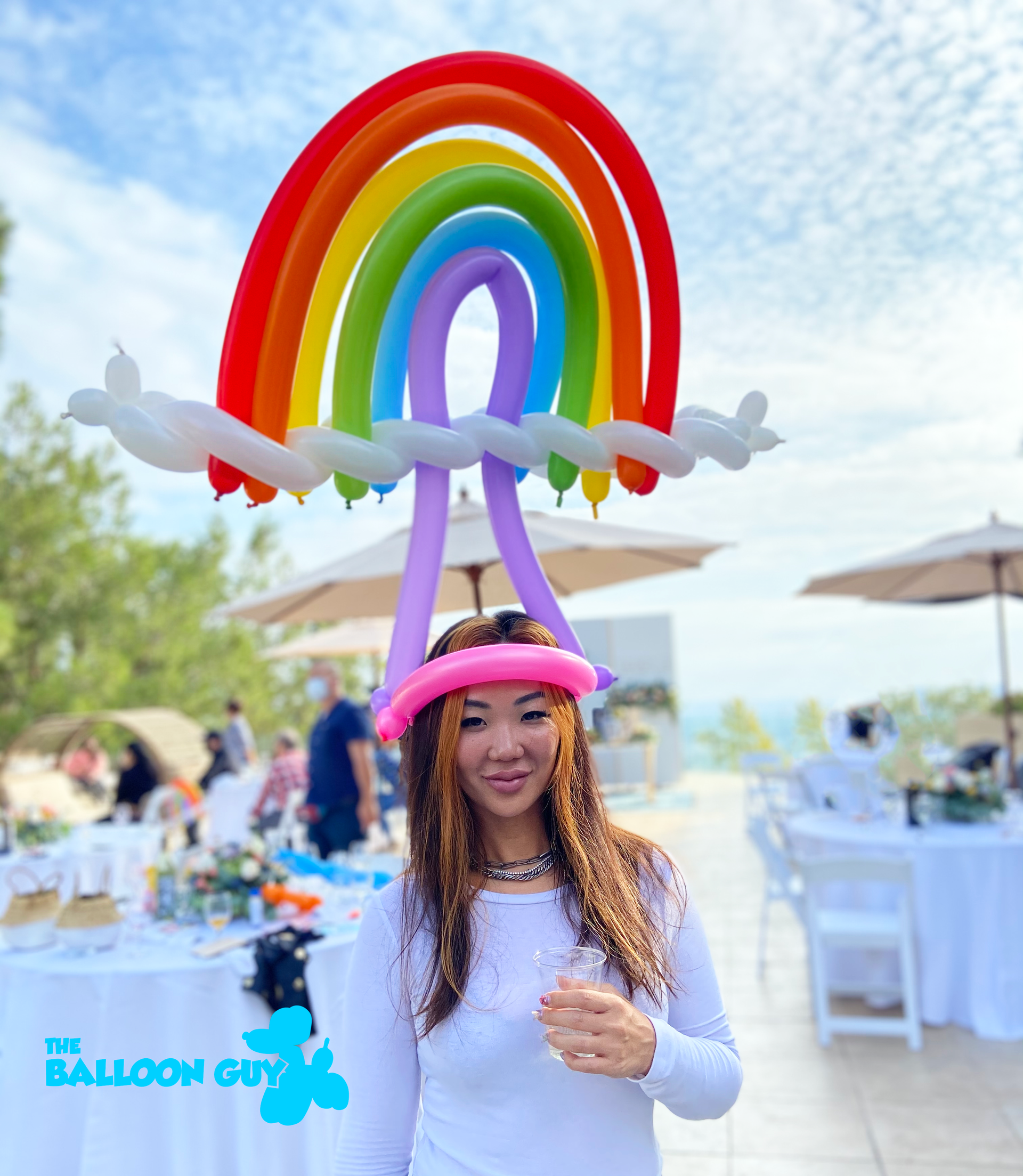A woman wearing a balloon hat with a rainbow on it
