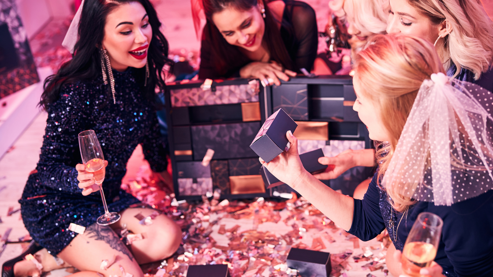 A group of women are sitting on the floor at a party.