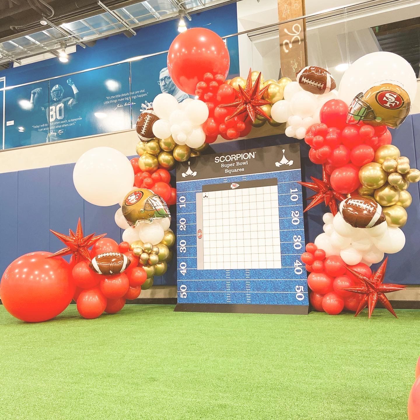 A bunch of balloons are sitting on top of a green field.