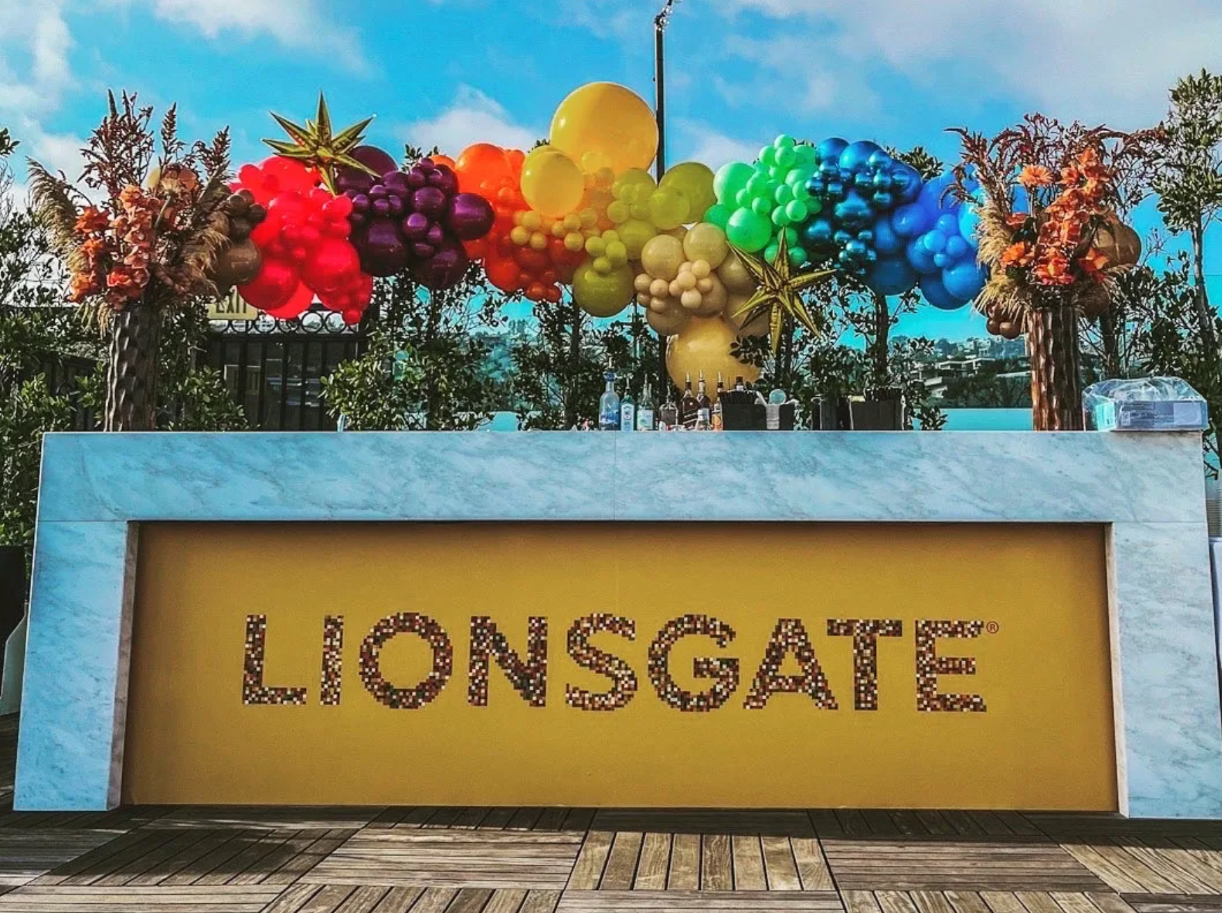 A sign for lionsgate is surrounded by balloons and flowers