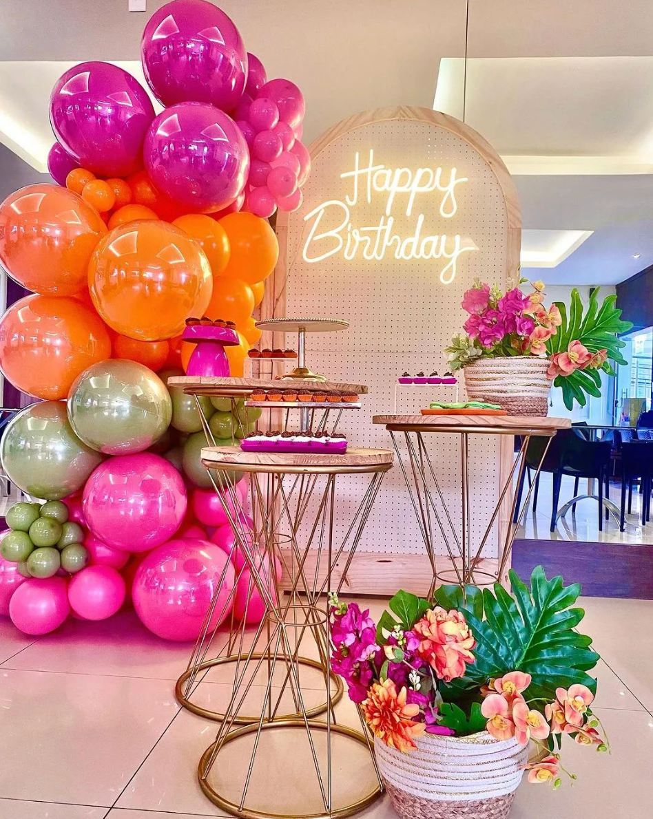 A room decorated with balloons and flowers for a birthday party.