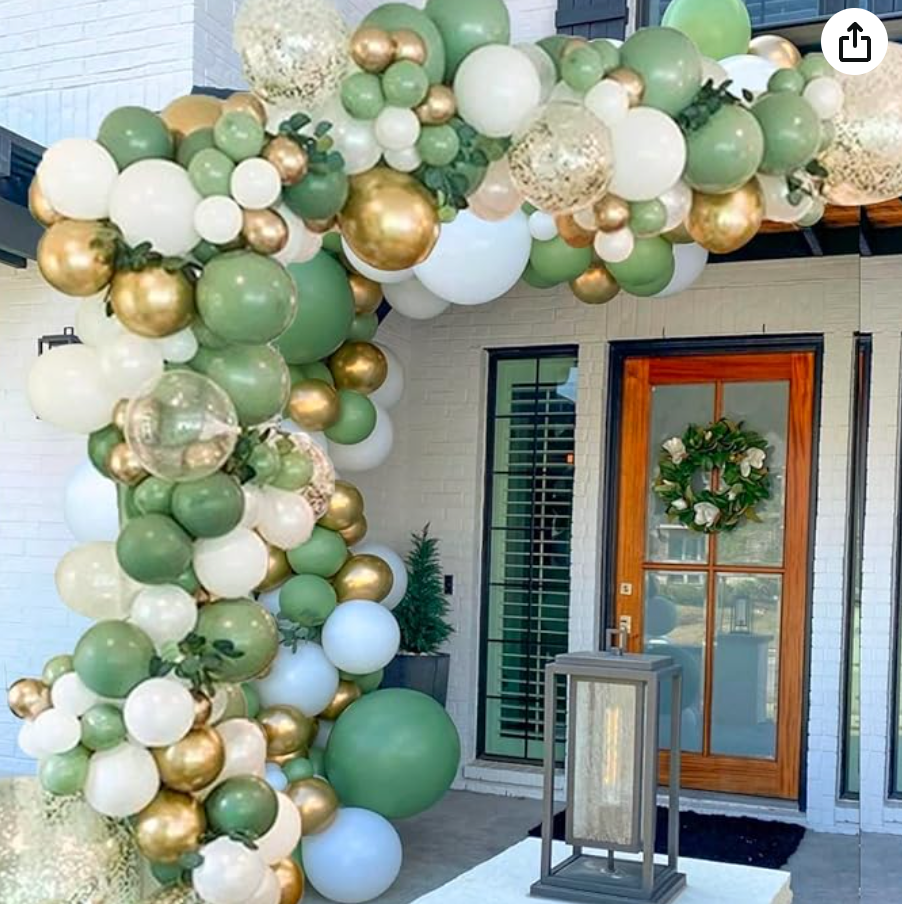 A bunch of green and gold balloons are hanging from the ceiling