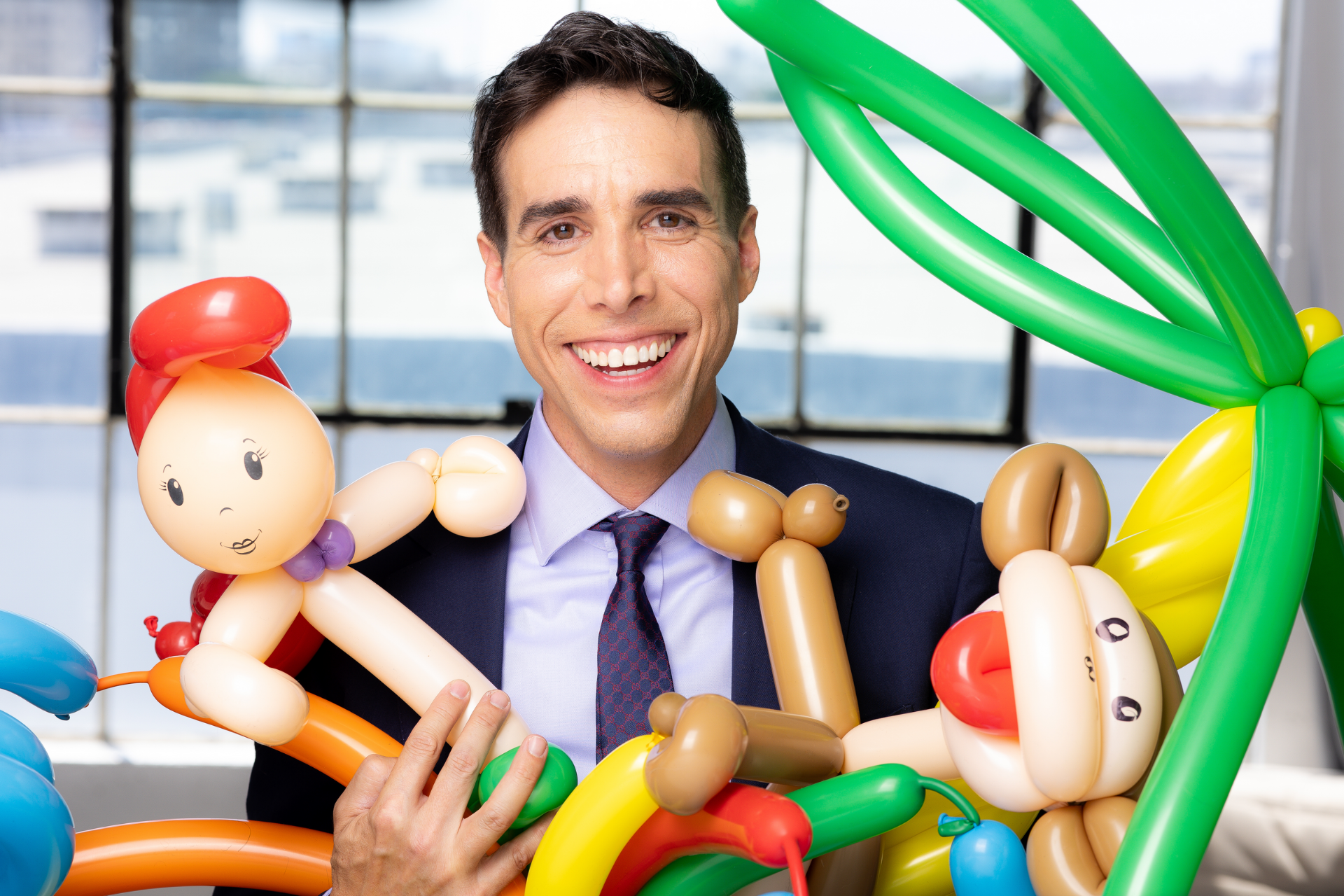 Celebrity Balloon Artist and Entrepreneur, Sean Edwards from The Balloon Guy in Los Angeles, CA is holding a bunch of balloons in his hands.