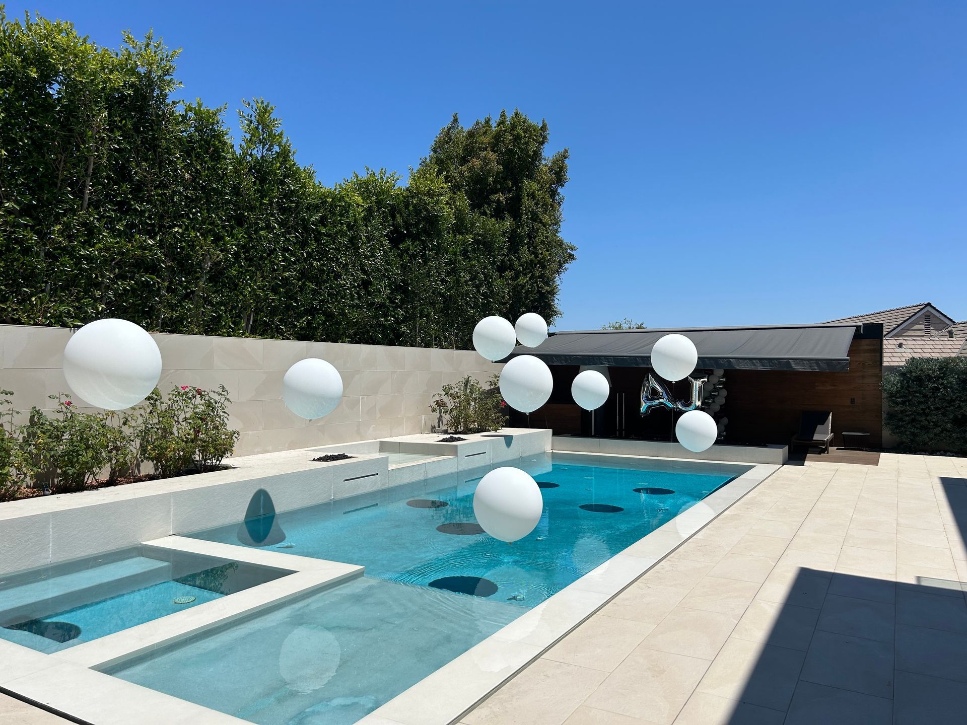 A swimming pool with white balloons floating in it