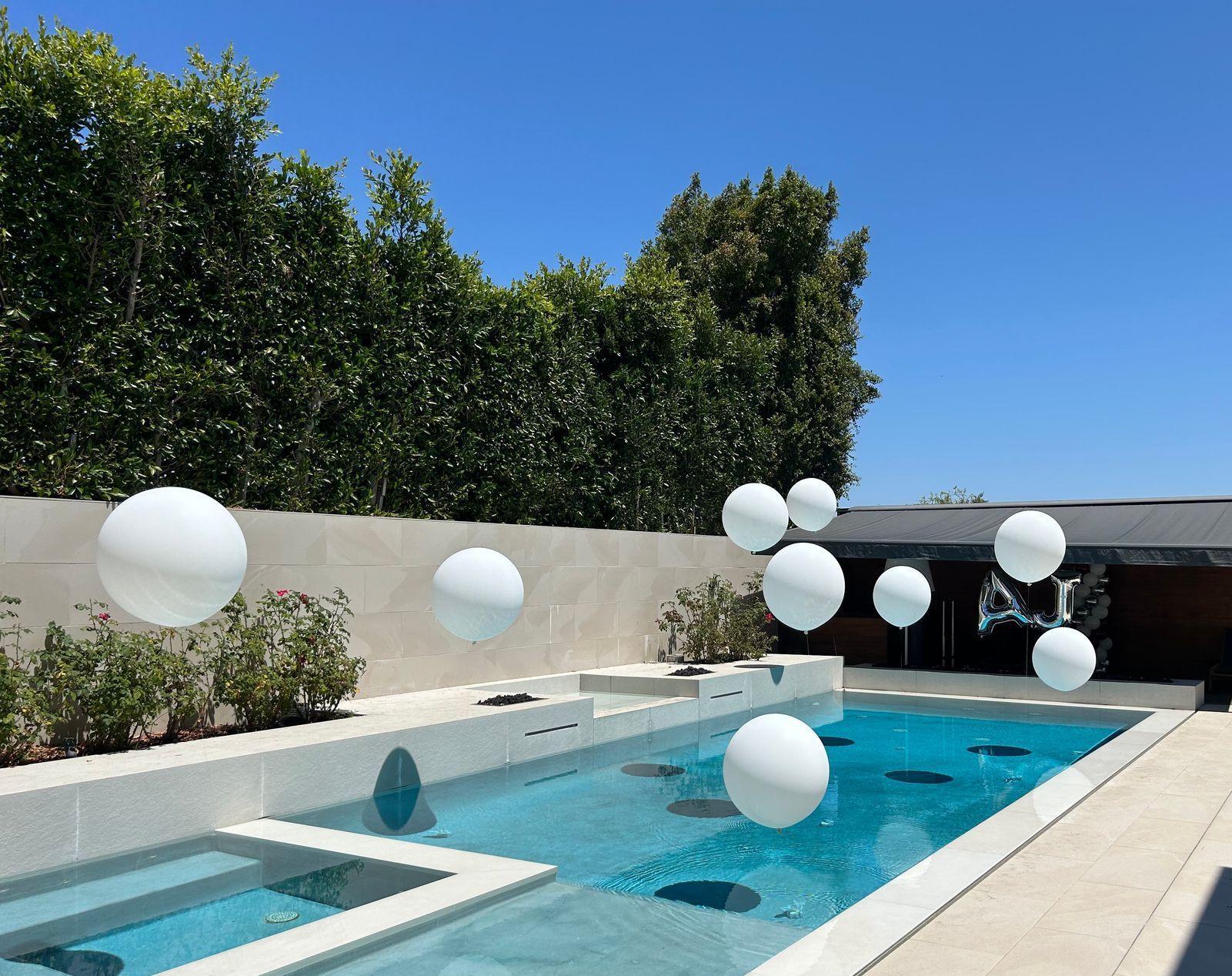 A swimming pool with white balloons floating in it