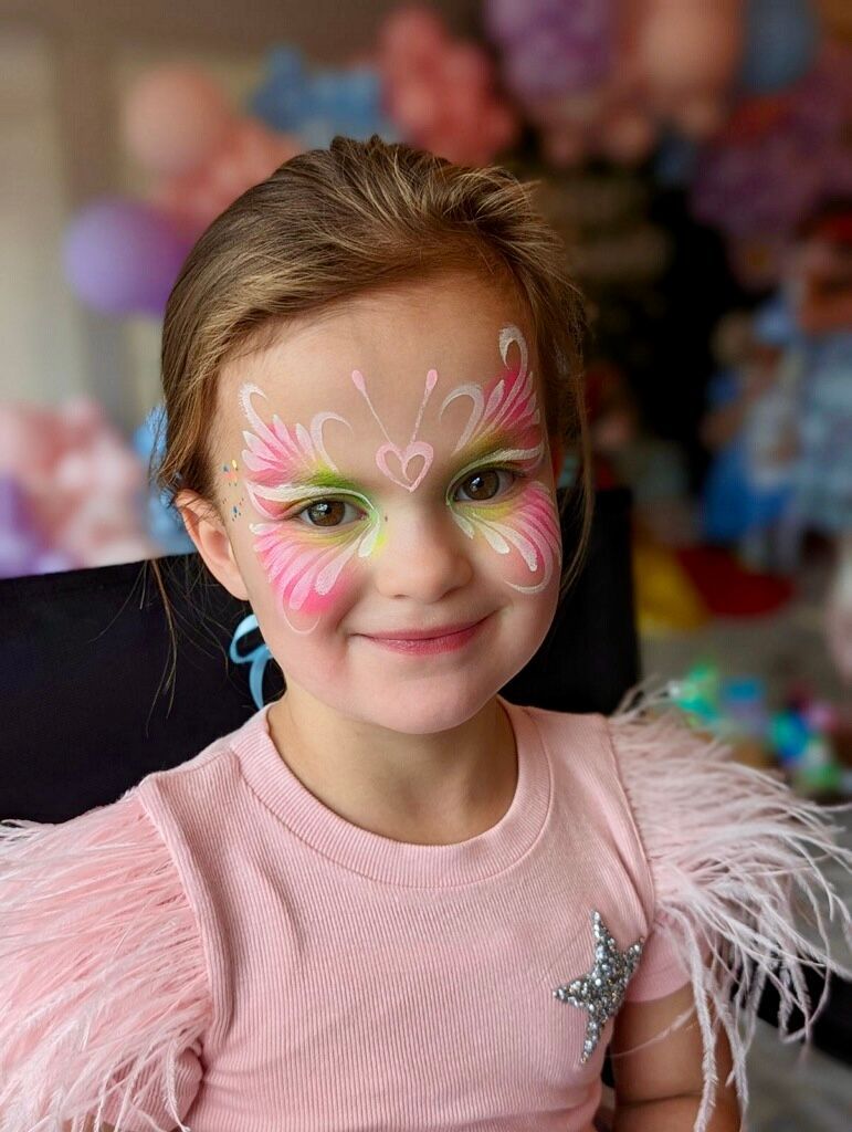 A little girl with a butterfly painted on her face.
