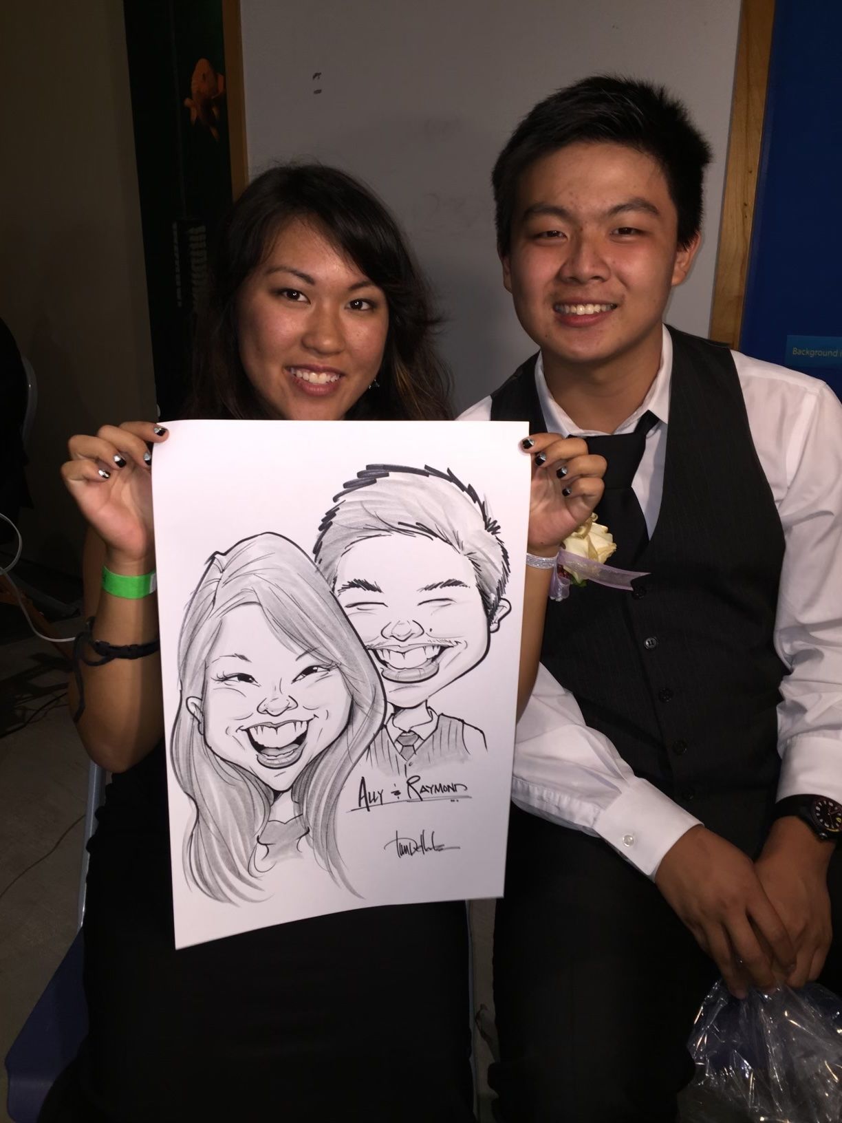 A man and a woman are holding a caricature of themselves