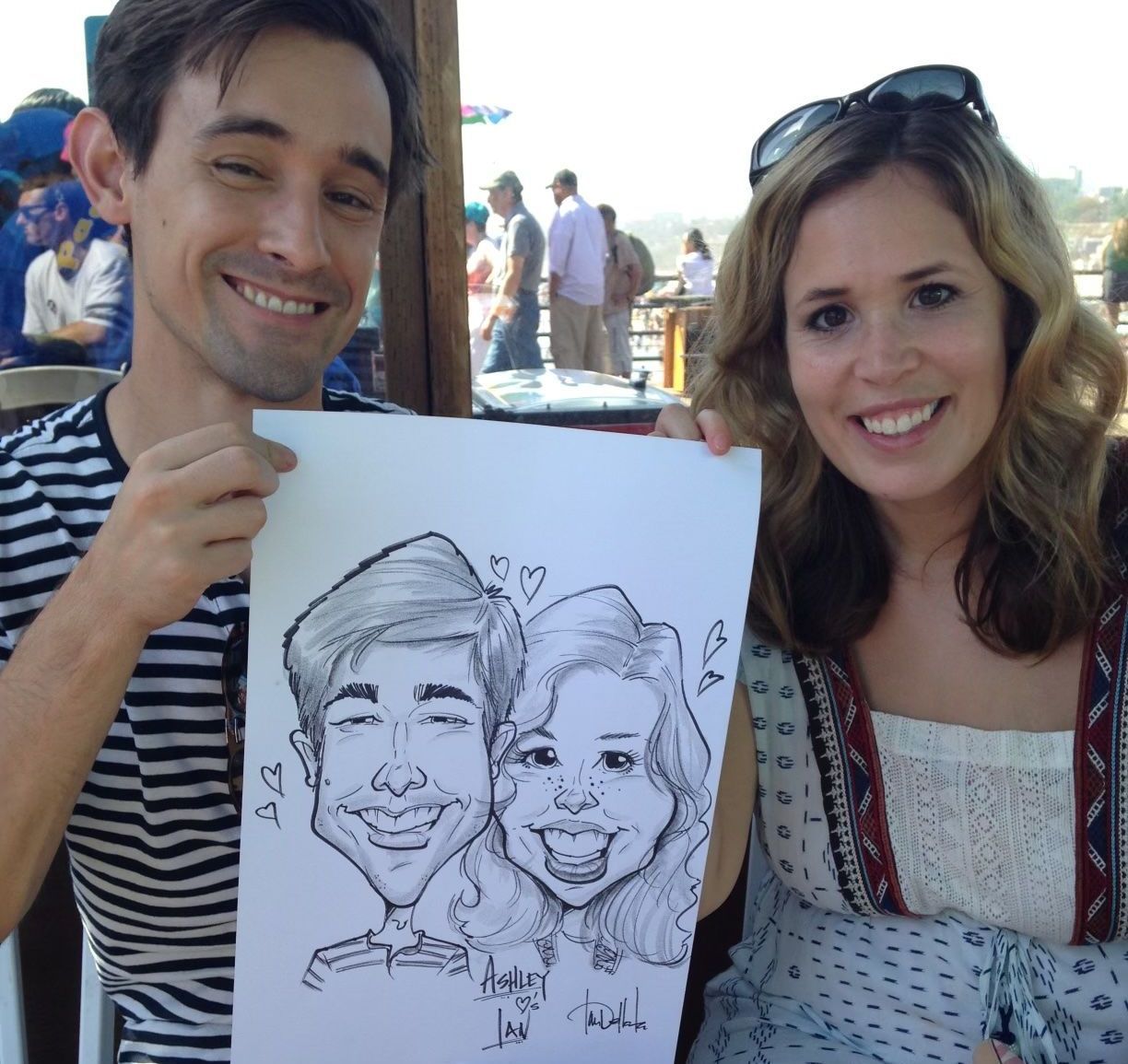 A man and a woman holding a drawing of a man and a woman