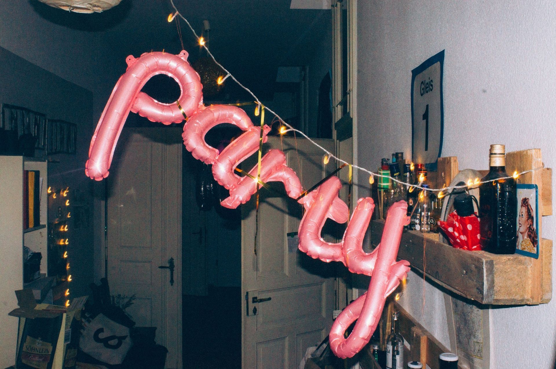 The word party is written in pink balloons on a string