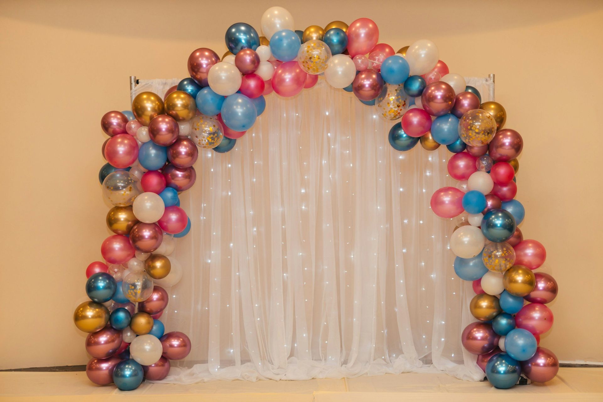 A bunch of balloons are sitting on top of a white curtain.