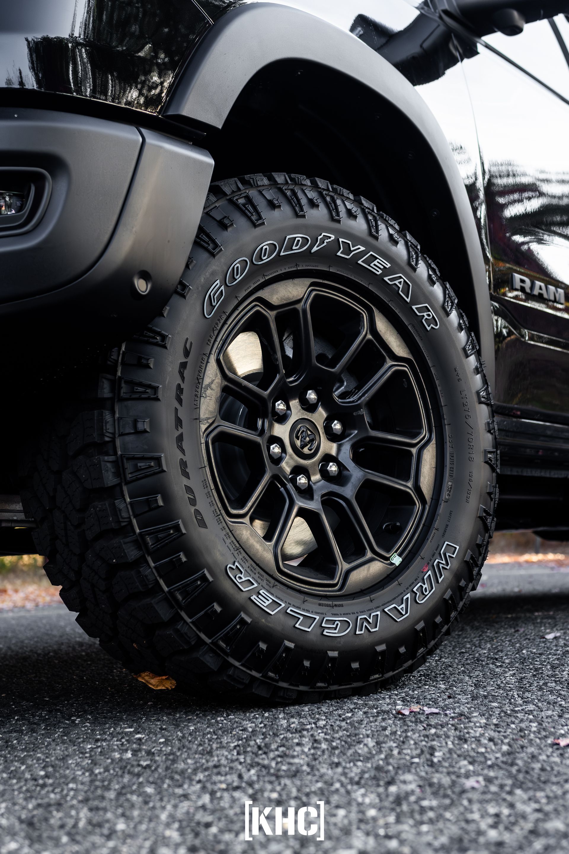 Black pickup truck wheel with Goodyear tires on asphalt.