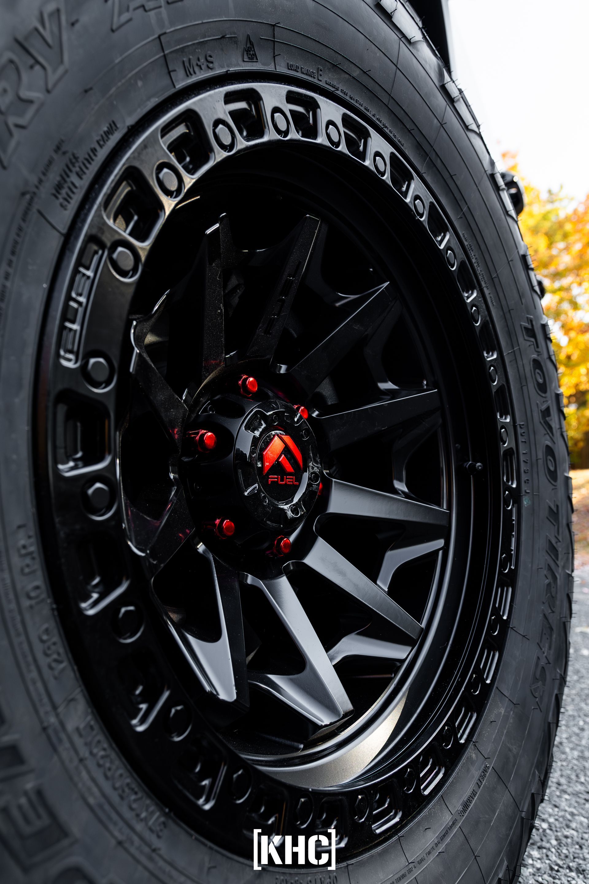 Black off-road vehicle wheel with red accents.