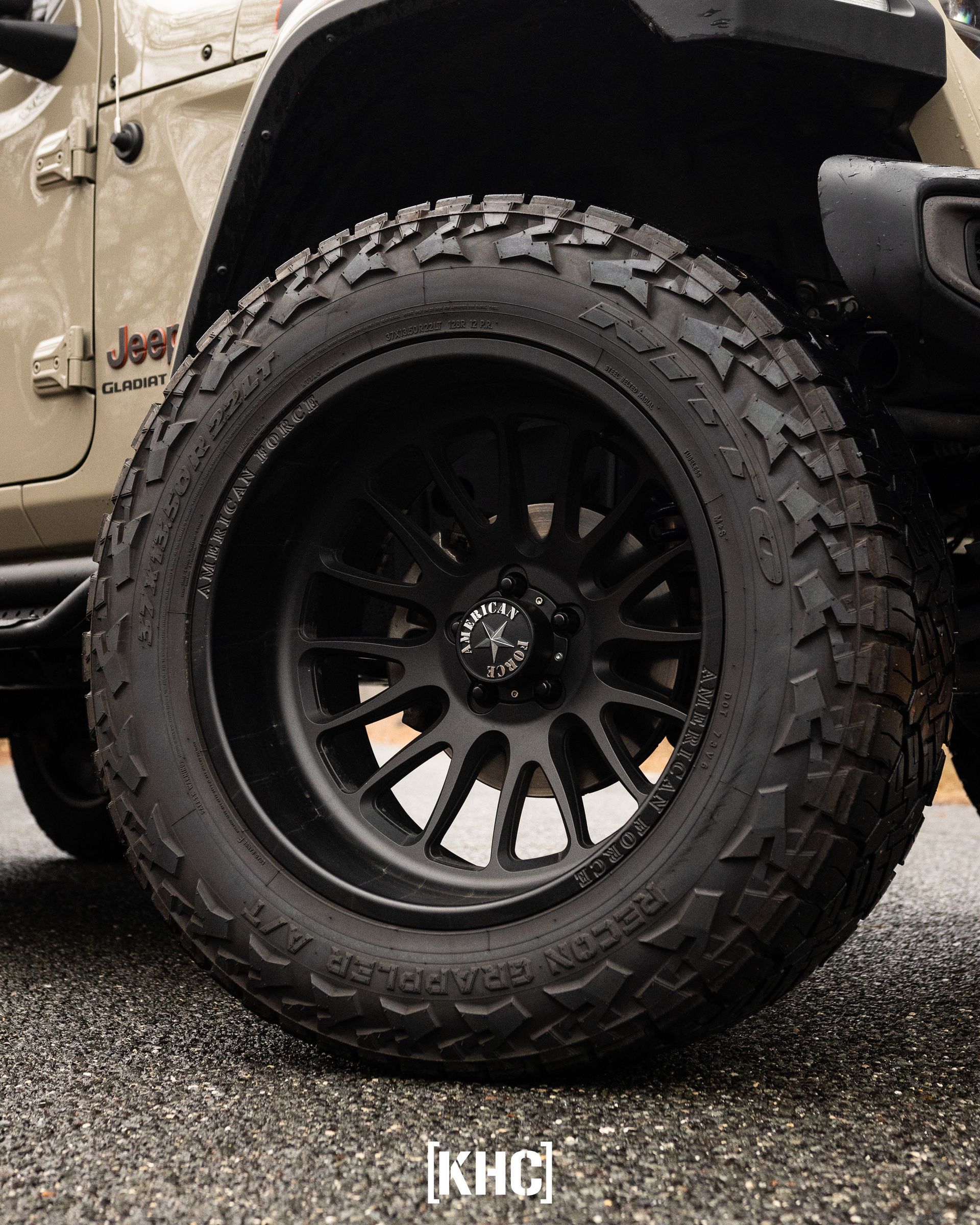 Black tire and rim on a tan Jeep.