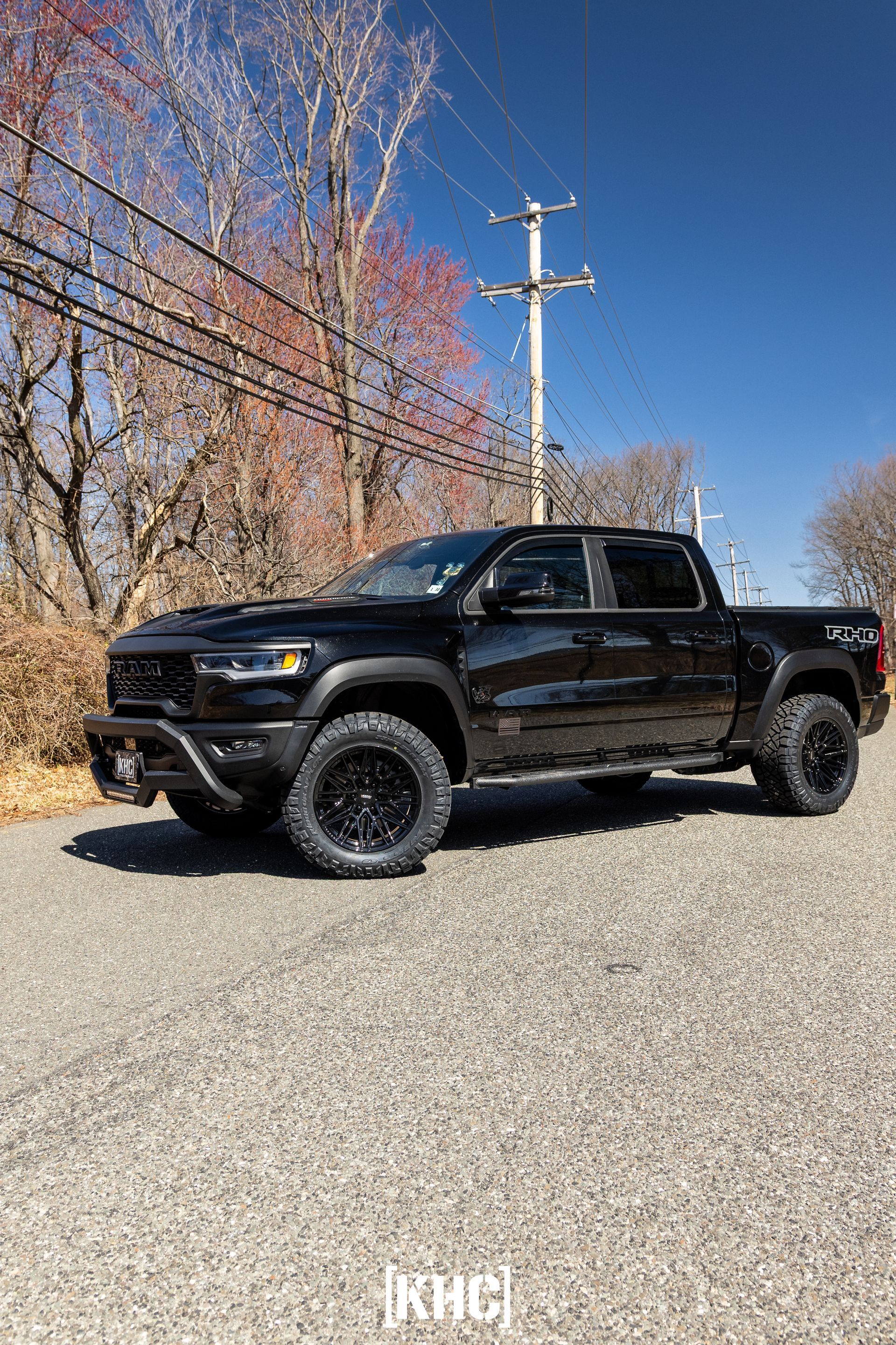 Black Ram TRX truck parked on a paved road, surrounded by trees.
