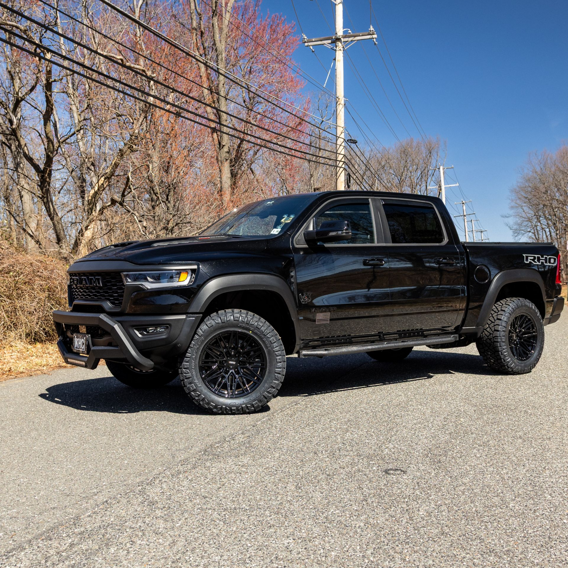Black Ram TRX truck parked on a paved road, surrounded by trees.