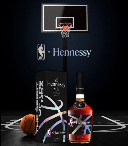 A bottle of hennessy vs next to a basketball on a basketball court