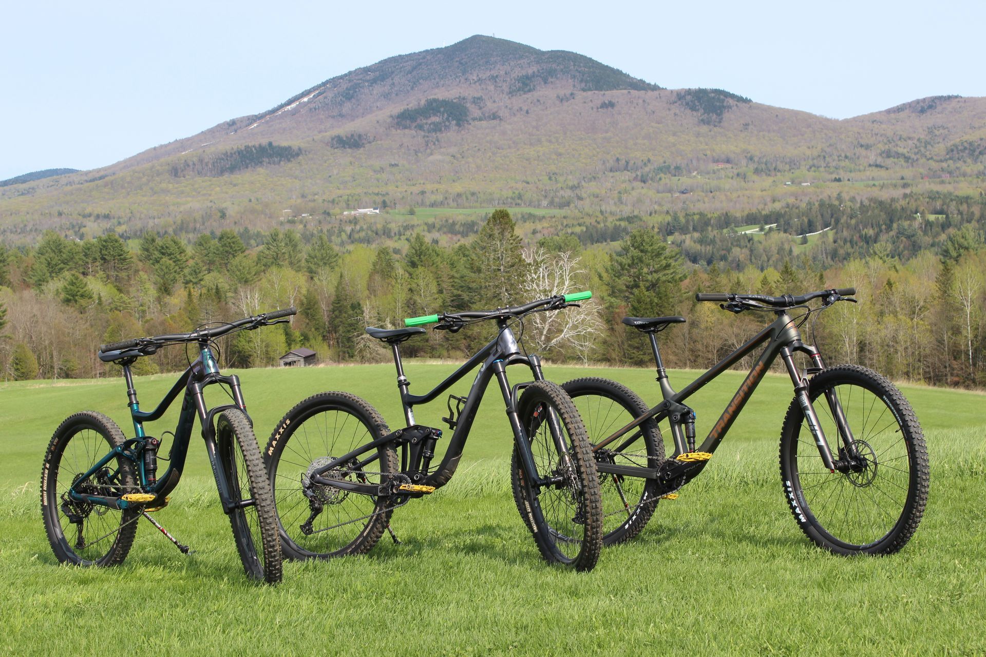 Three mountain bikes in a field