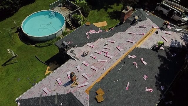 an aerial view of a house being remodeled with a pool in the backyard Birds Eye Roofing Group.