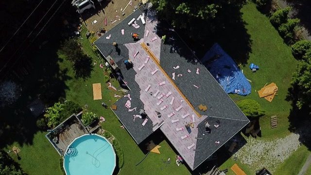 an aerial view of a house being remodeled with a pool in the backyard Birds Eye Roofing Group.
