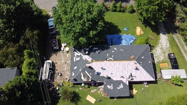 an aerial view of a house under construction with a roof being installed Birds Eye Roofing Group.
