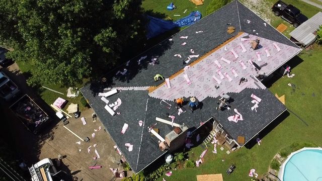 an aerial view of a house being remodeled with a pool in the backyard Birds Eye Roofing Group.