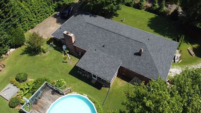 an aerial view of a house with a pool in the backyard Birds Eye Roofing Group.