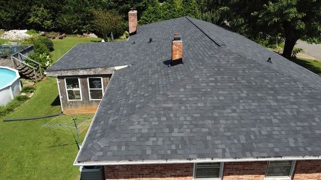 an aerial view of a house with a new roof and a pool Birds Eye Roofing Group.