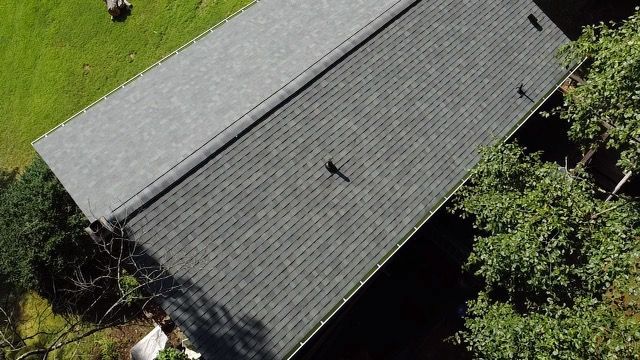 an aerial view of a roof of a house with trees in the background Birds Eye Roofing Group.