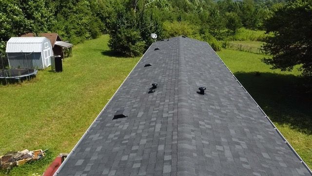 an aerial view of a roof of a house in a grassy field Birds Eye Roofing Group.