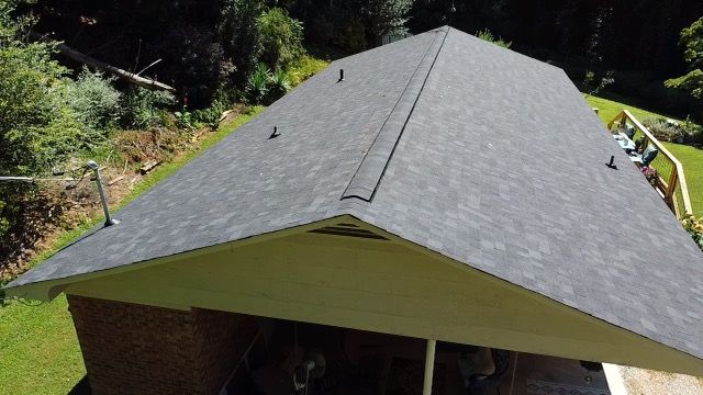 an aerial view of a house with a black roof Birds Eye Roofing Group.