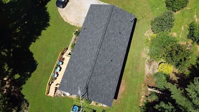 an aerial view of a house with a car parked in front of it Birds Eye Roofing Group.