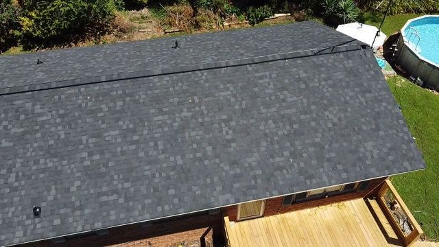 an aerial view of a roof of a house with a pool in the background Birds Eye Roofing Group.