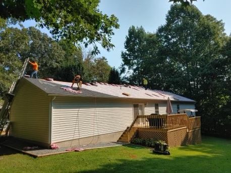 a man is working on the roof of a house Birds Eye Roofing Group.