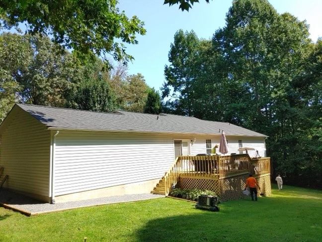 a white house with a large deck in the backyard Birds Eye Roofing Group
