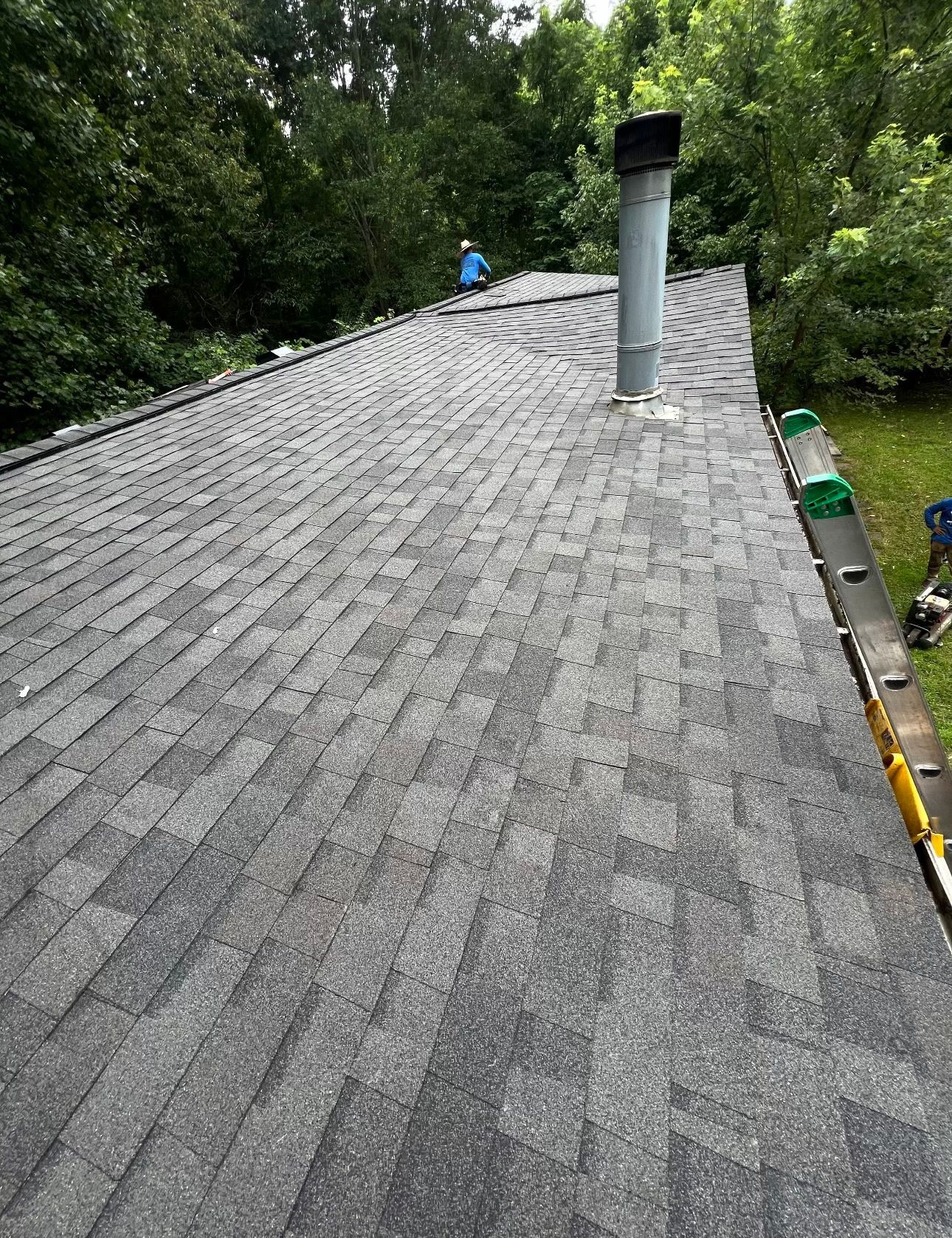 a roof with a chimney on top of it and trees in the background Birds Eye Roofing Group.