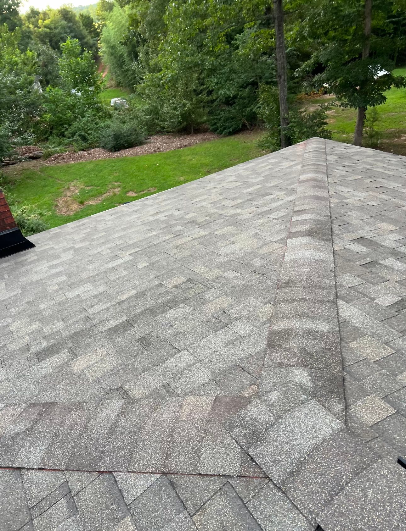 a roof with a lot of shingles on it and trees in the background Birds Eye Roofing Group.
