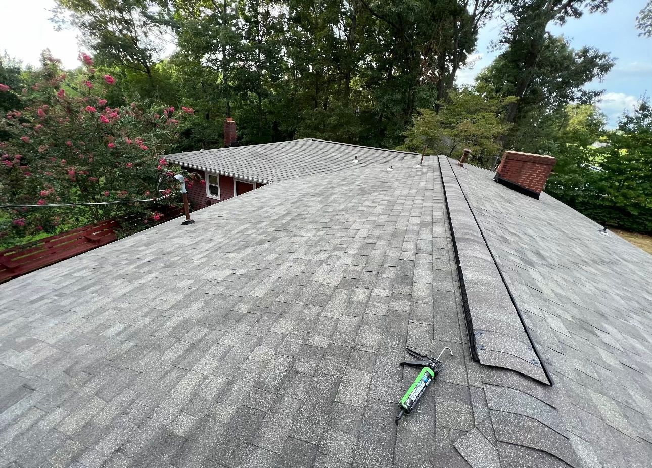 a close up of a roof with a bottle of sealant on it Birds Eye Roofing Group.