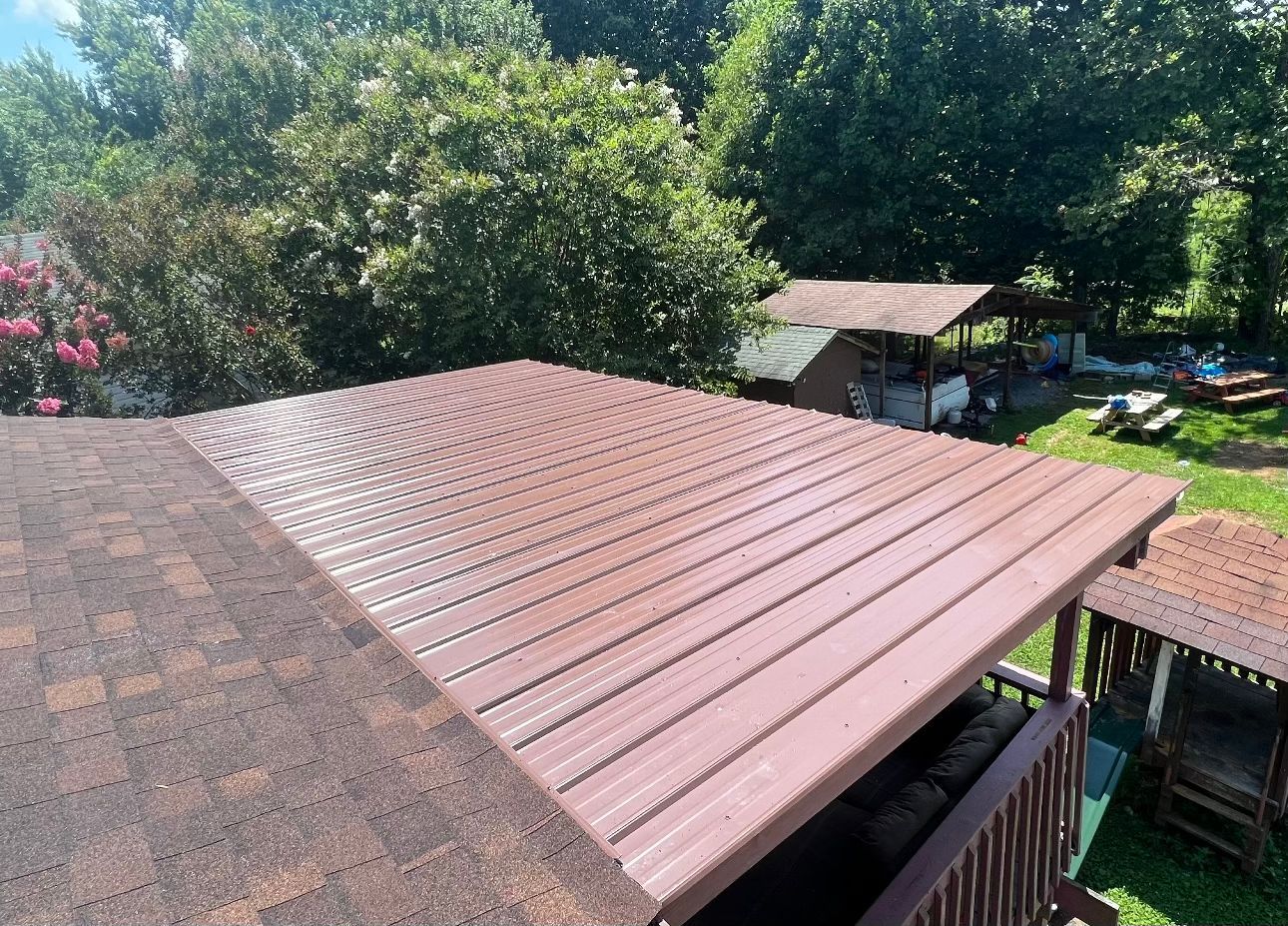 an aerial view of a roof with a wooden deck and trees in the background Birds Eye Roofing Group.