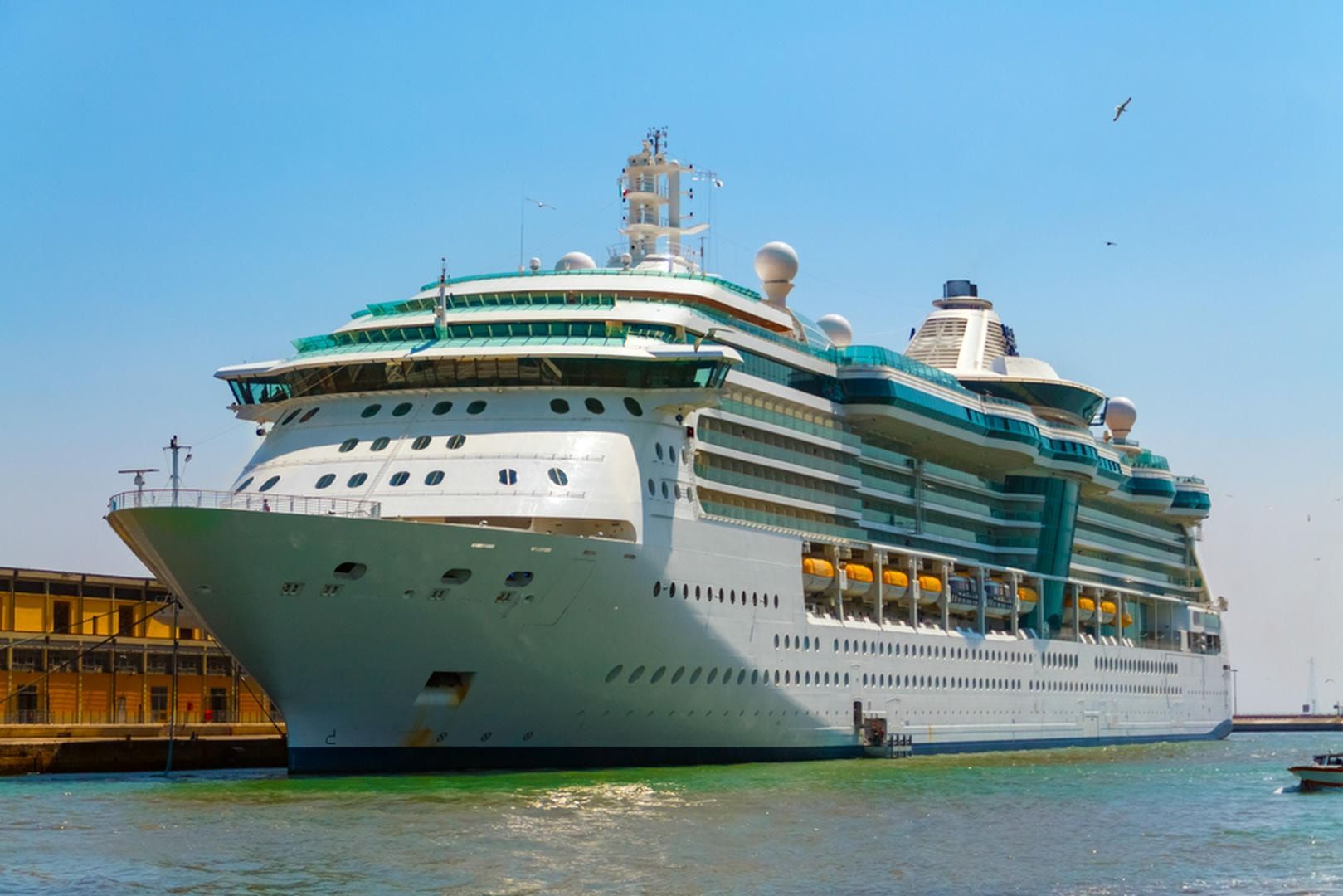 A large cruise ship is docked in a harbor.