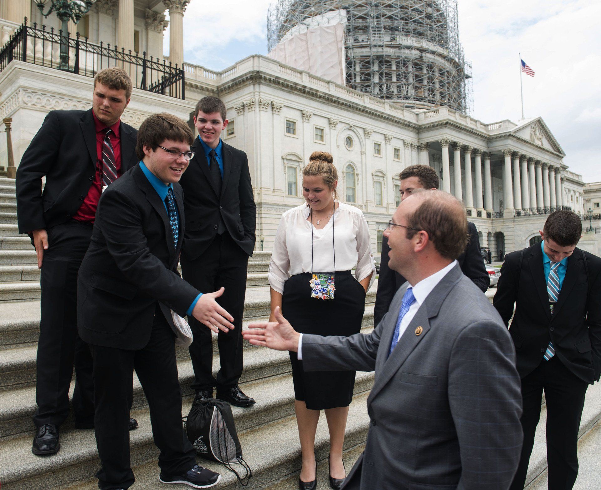 A group of people standing on the steps of the capitol building