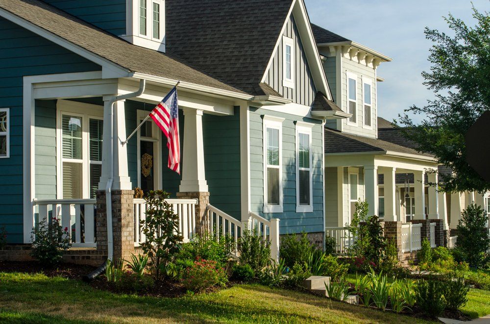 A row of houses and a front porch with the American Flag