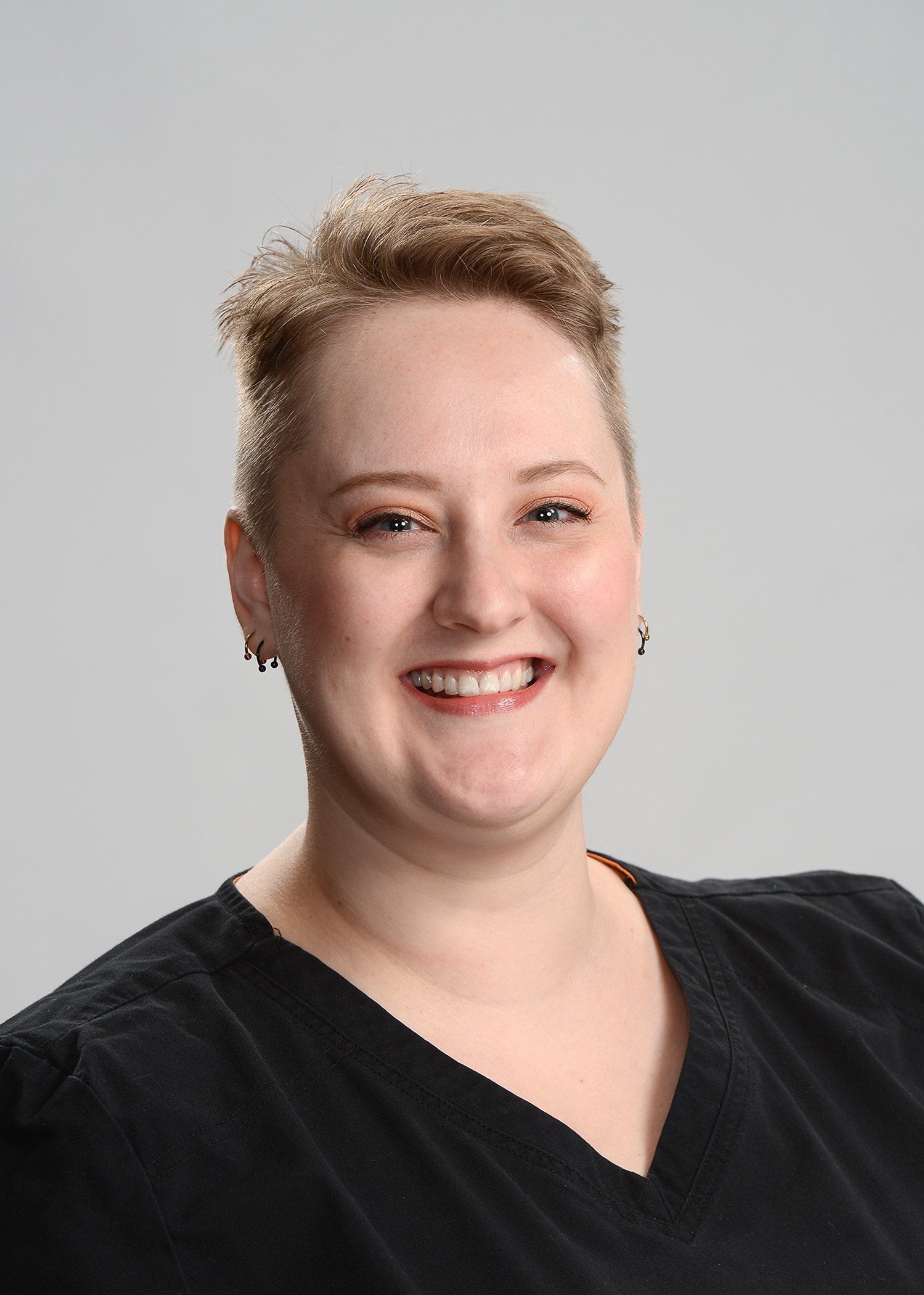 A woman in a black shirt is smiling for the camera.