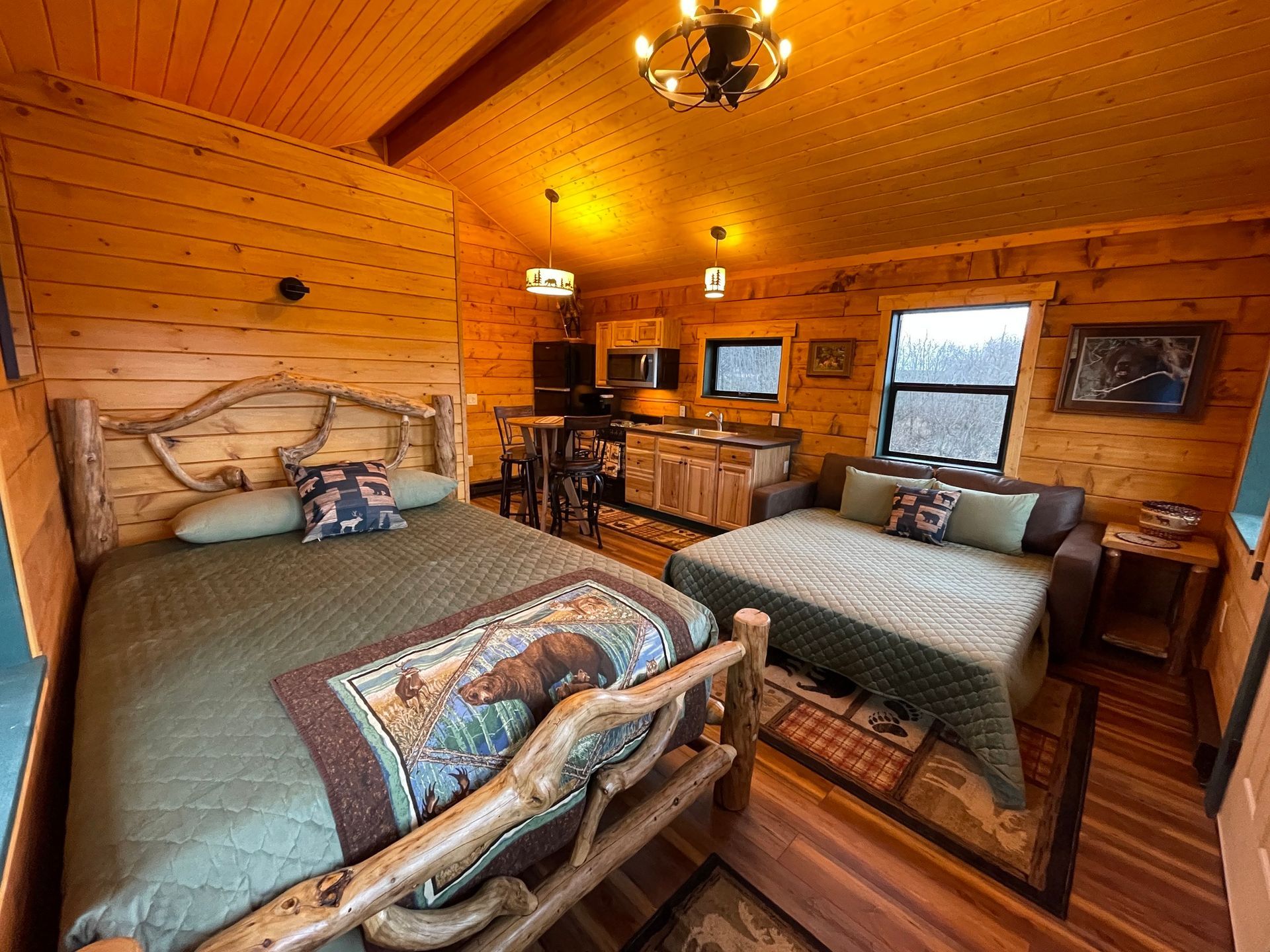 A bedroom in a log cabin with a bed and a couch.