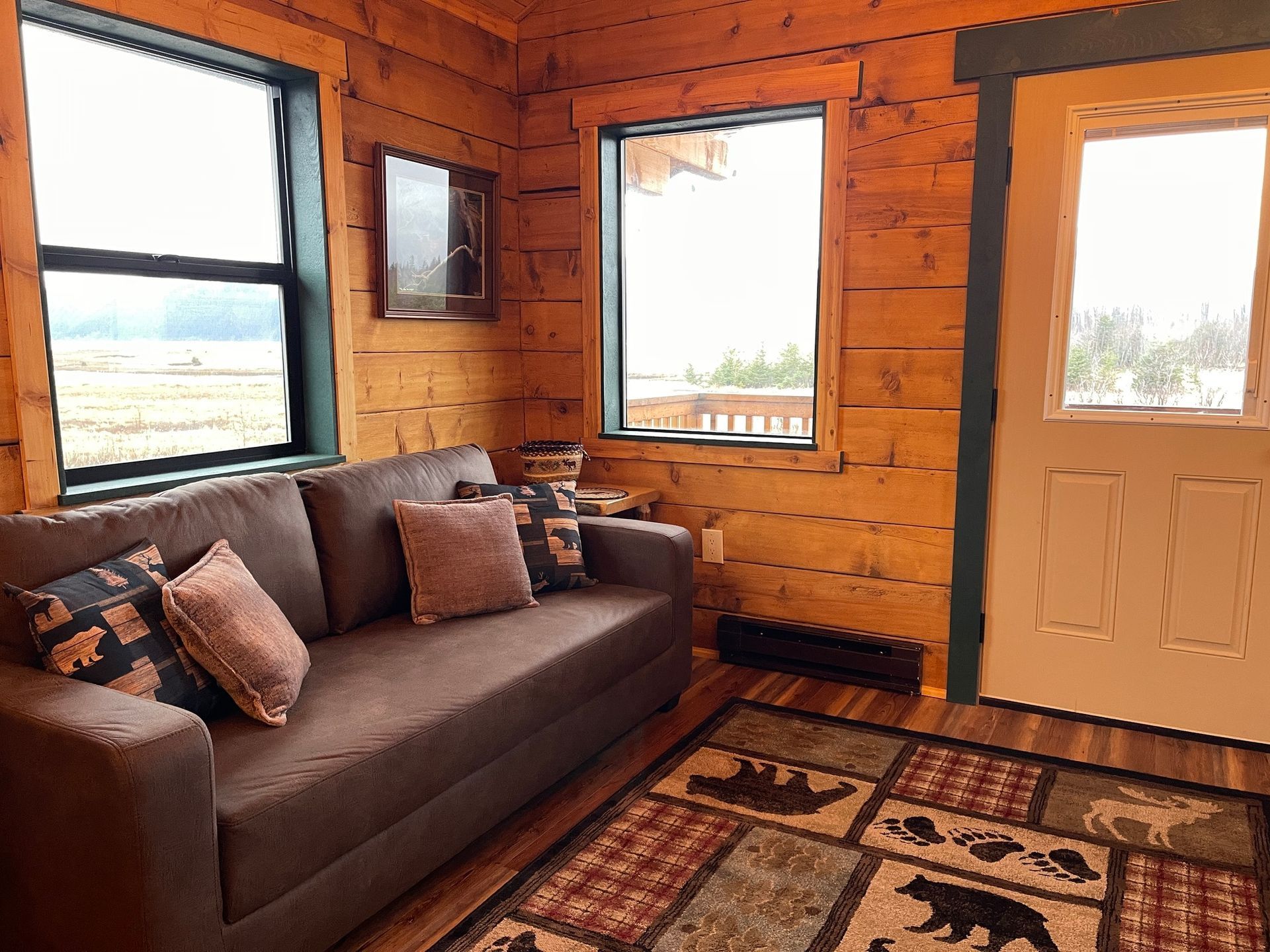 A living room in a log cabin with a couch and a rug.