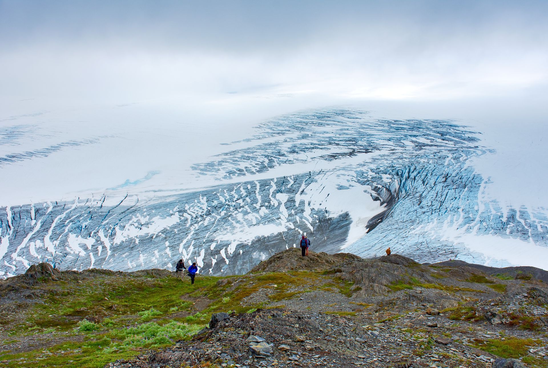 A group of people are standing on top of a snow covered mountain.