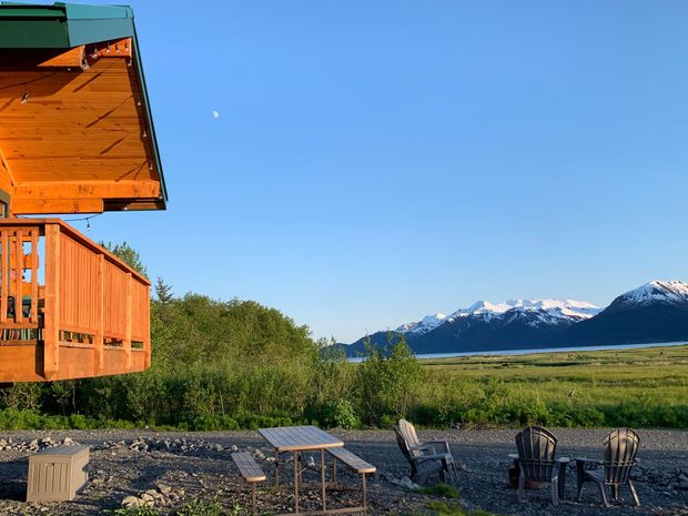 A living room in a log cabin with a couch and a rug.