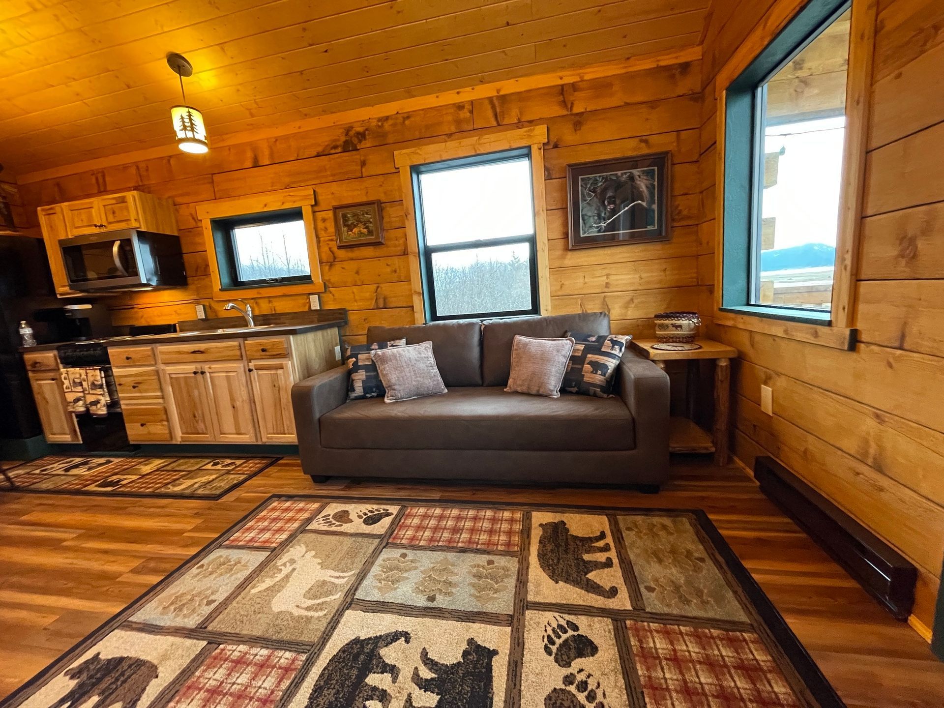 A living room in a log cabin with a couch and a rug.